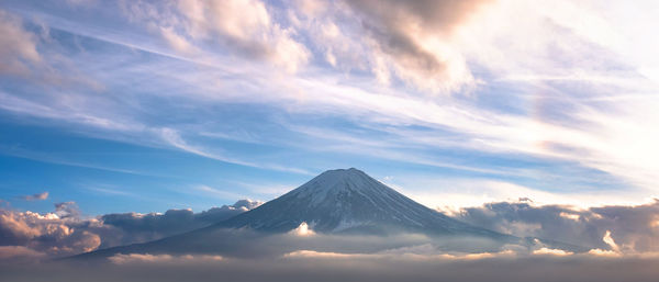 Scenic view of snowcapped mountain against cloudy sky