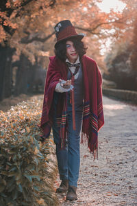 Full length of man cosplaying mad hatter standing in park during autumn