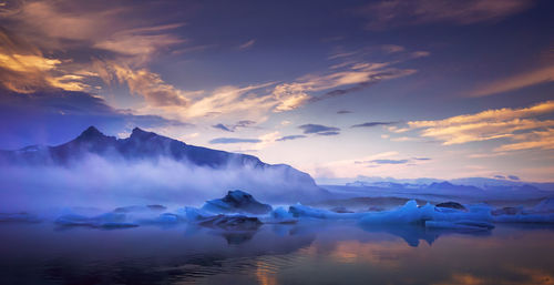 Scenic view of snowcapped mountains against sky during sunset