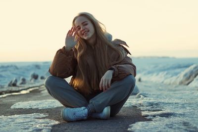Portrait of young woman sitting on beach
