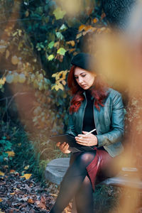 Young woman looking away while using mobile phone