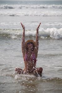 Woman playing with water at shore