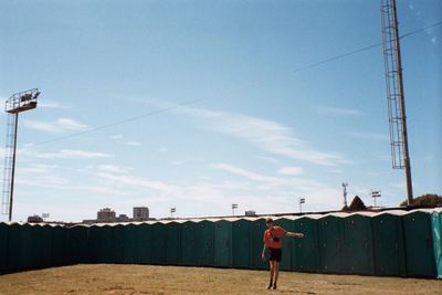 Rear view of woman standing against sky