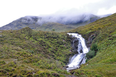 Scenic view of waterfall against sky