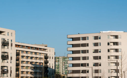 Low angle view of buildings against clear blue sky