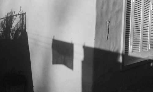 Clothesline shadow on house wall