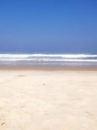 Scenic view of beach against blue sky