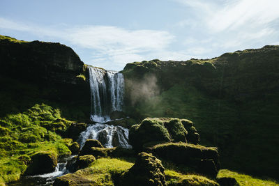 Scenic view of waterfall against sky