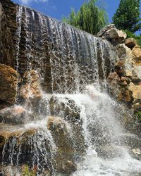 Scenic view of waterfall against sky