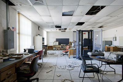 Empty chairs and tables in abandoned room
