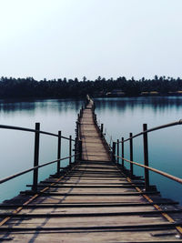 Pier over lake against clear sky