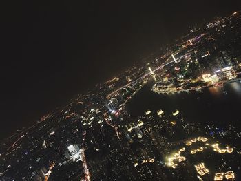 High angle view of illuminated buildings against sky at night