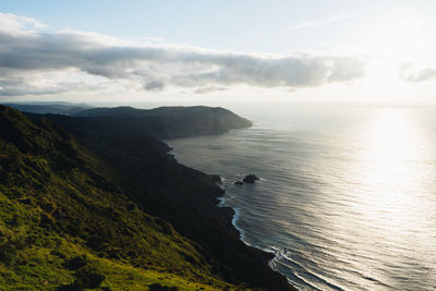 Scenic view of sea and mountains against sky