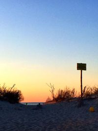 Scenic view of snow covered land against clear sky during sunset