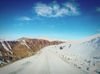 Scenic view of mountain road against cloudy sky