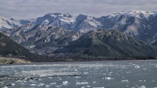 Scenic view of lake and snowcapped mountains against sky