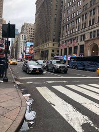 Cars on street by buildings in city