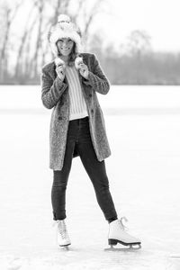 Full length portrait of woman standing on snow