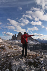 Rear view of man standing on mountain against sky - tre cime di lavaredo - dolomiti - italy