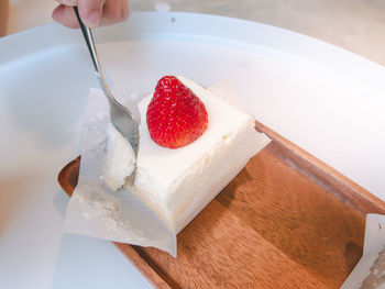 Close-up of hand holding ice cream on table