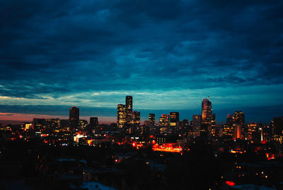 Illuminated cityscape against sky at night