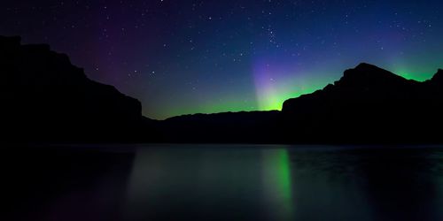 Scenic view of silhouette mountains against sky at night