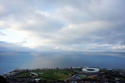 High angle view of city by sea against sky