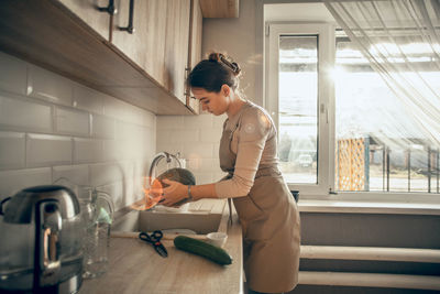 Young woman washing fresh pumpkin. cooking a vegan lunch. concept of healthy nutrition