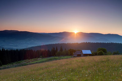 Scenic view of field against clear sky during sunset