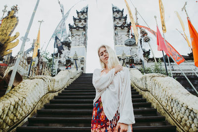 Young woman standing on staircase at temple gate