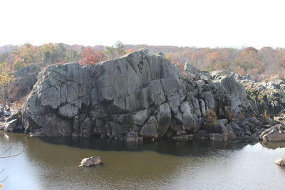Rocks floating on water against sky
