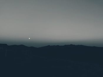 Silhouette landscape against clear sky at night