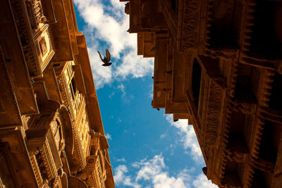 Low angle view of buildings against cloudy sky