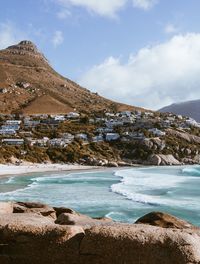 Scenic view of lake by mountains against sky