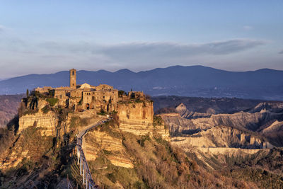 Castle on mountain against cloudy sky