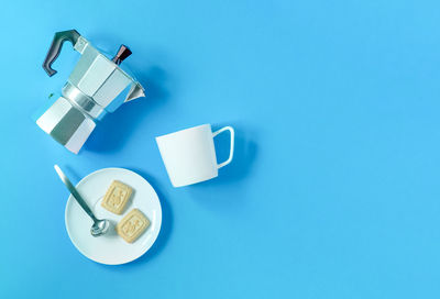 High angle view of coffee cup against blue background