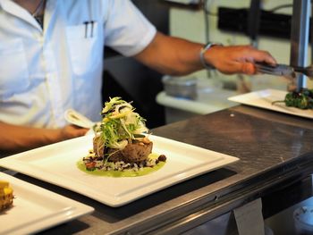 Close-up of man preparing food in plate