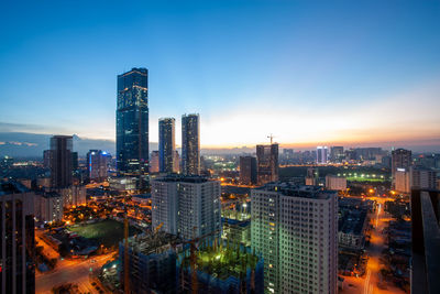 Illuminated buildings in city against sky