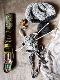 High angle view of knitting needles and ball of yarn on the blanket