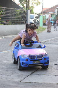 Portrait of a girl sitting on car