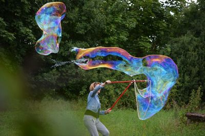 Full length of man with bubbles in park