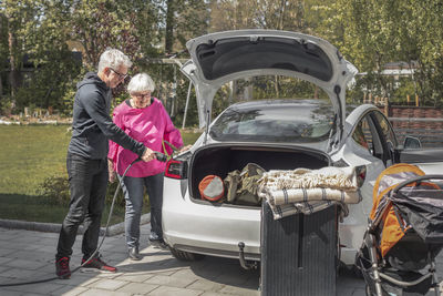 Couple charging electric car