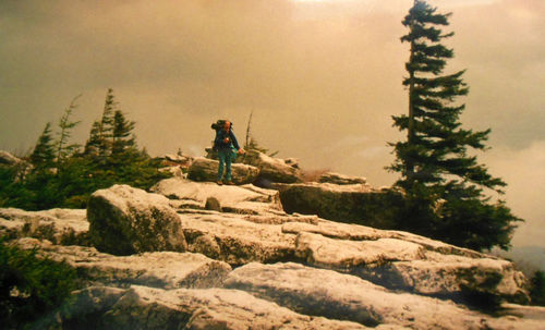 People on rock against sky