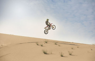 Low angle view of man riding motorcycle at desert