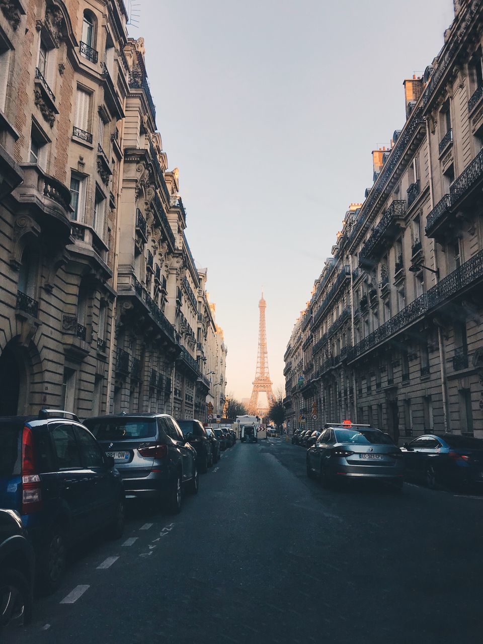 CARS ON ROAD AGAINST CLEAR SKY IN CITY