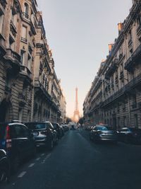 Cars on street in city against clear sky