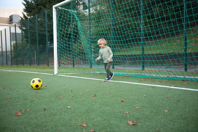 Children playing soccer on field