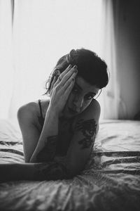 Portrait of woman sitting on bed at home