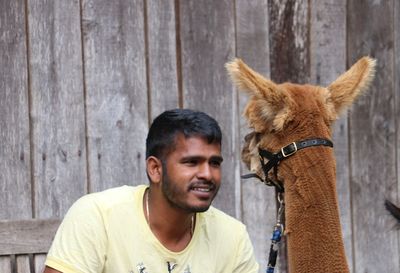 Smiling man looking at alpaca