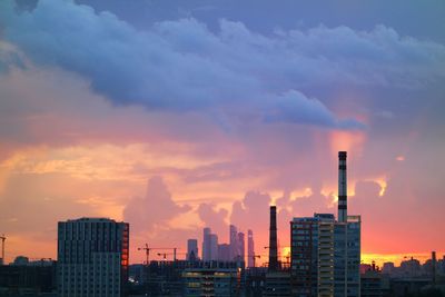 Buildings in city against sky during sunset